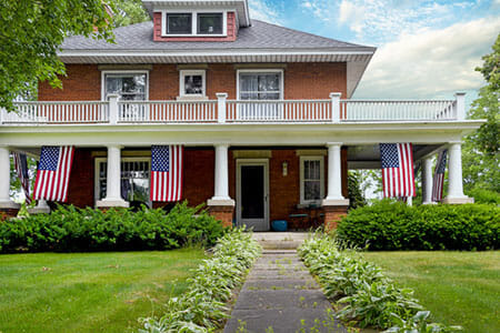 American flag decorations on front porch of old brick home Aging in Place Universal Design home front